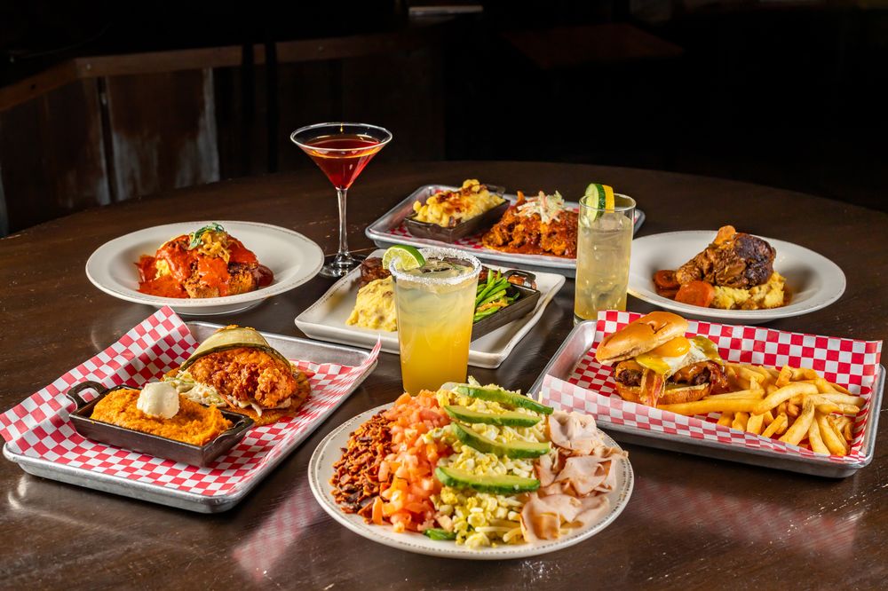 Table with a burger, fries and Southern dishes in warm restaurant light